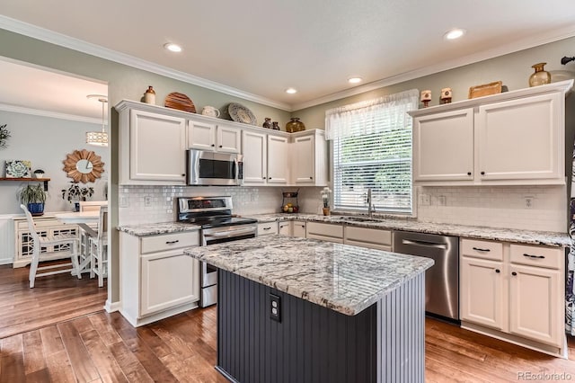 16341 Maple Rock Ct, Parker, CO 80134 - kitchen with appliances with stainless steel finishes, a sink, white cabinetry, wood finished floors, and crown molding