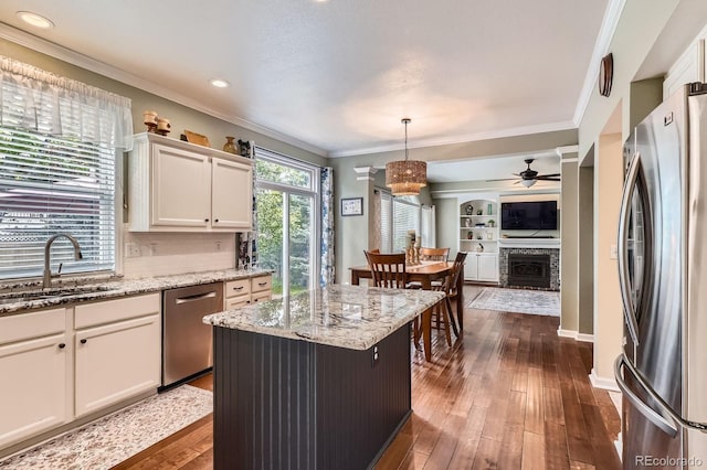 16341 Maple Rock Ct, Parker, CO 80134 - kitchen with appliances with stainless steel finishes, a sink, ceiling fan, dark wood-type flooring, and ornamental molding