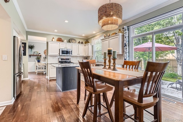 16341 Maple Rock Ct, Parker, CO 80134 - dining room with healthy amount of natural light, ornamental molding, a chandelier, dark wood-style floors, and baseboards
