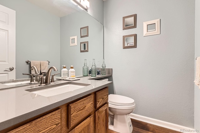 16341 Maple Rock Ct, Parker, CO 80134 - bathroom with toilet, wood finished floors, vanity, and baseboards