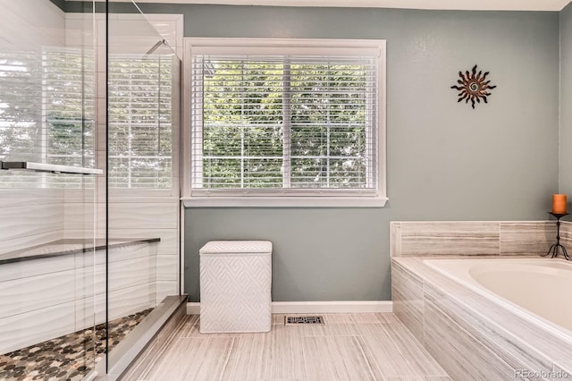 16341 Maple Rock Ct, Parker, CO 80134 - bathroom featuring a bath, a stall shower, and baseboards