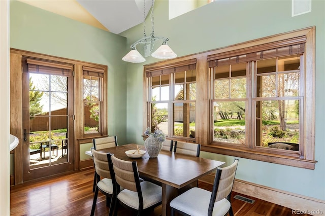 dining space featuring wood finished floors and lofted ceiling