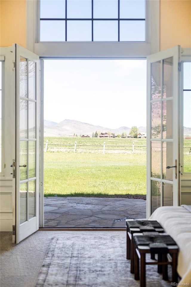 entryway featuring a mountain view, a rural view, french doors, and carpet flooring