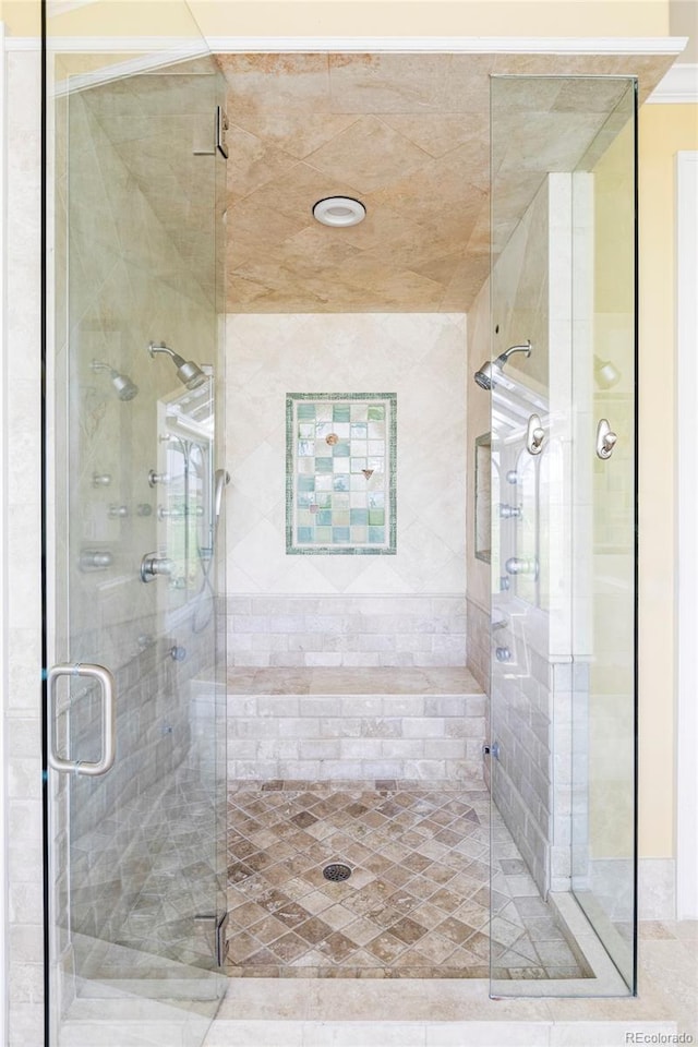 bathroom with a stall shower and crown molding