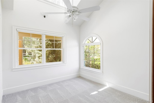 carpeted empty room featuring vaulted ceiling, baseboards, and ceiling fan