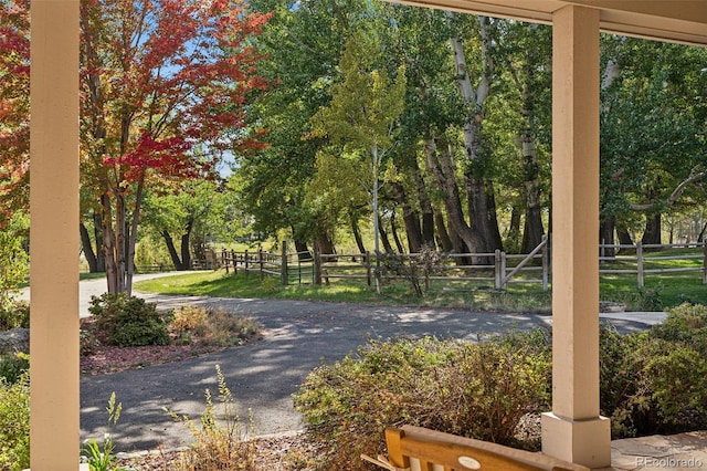 view of home's community featuring fence and view of wooded area