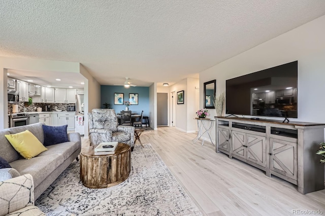 14390 E Marina Dr Unit 403, Aurora, CO 80014 - living area featuring light wood-type flooring, ceiling fan, a textured ceiling, and baseboards