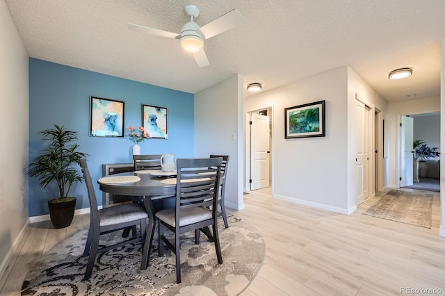 14390 E Marina Dr Unit 403, Aurora, CO 80014 - dining room with light wood-type flooring, ceiling fan, a textured ceiling, and baseboards