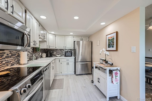 14390 E Marina Dr Unit 403, Aurora, CO 80014 - kitchen with stainless steel appliances, recessed lighting, white cabinets, tasteful backsplash, and light wood-type flooring
