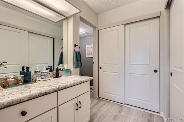 14390 E Marina Dr Unit 403, Aurora, CO 80014 - bathroom featuring vanity, wood finished floors, and a textured ceiling