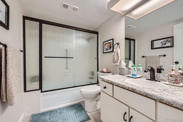 14390 E Marina Dr Unit 403, Aurora, CO 80014 - bathroom with vanity, toilet, combined bath / shower with glass door, and wood finished floors