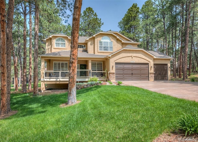 1530 Woodrose Ct, Colorado Springs, CO 80921 - view of front of home with stucco siding, a front yard, concrete driveway, a garage, and covered porch