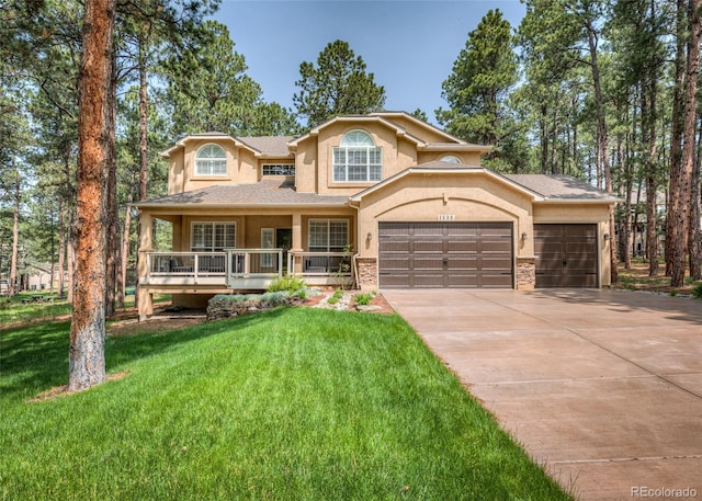 1530 Woodrose Ct, Colorado Springs, CO 80921 - view of front facade with stucco siding, a front yard, concrete driveway, an attached garage, and covered porch