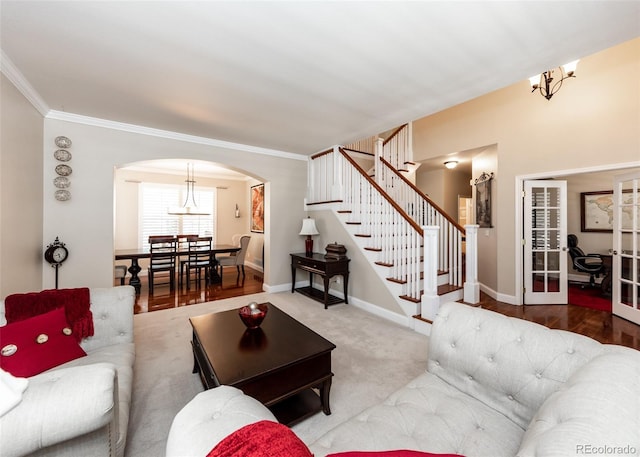 1530 Woodrose Ct, Colorado Springs, CO 80921 - living area featuring arched walkways, a chandelier, ornamental molding, stairs, and baseboards