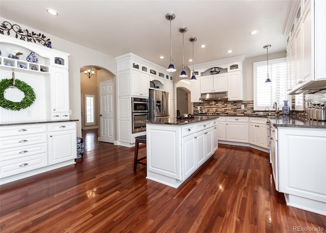 1530 Woodrose Ct, Colorado Springs, CO 80921 - kitchen with arched walkways, appliances with stainless steel finishes, a sink, a center island, and recessed lighting