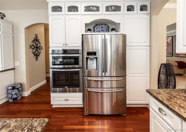 1530 Woodrose Ct, Colorado Springs, CO 80921 - kitchen with appliances with stainless steel finishes, arched walkways, dark wood finished floors, and dark stone countertops