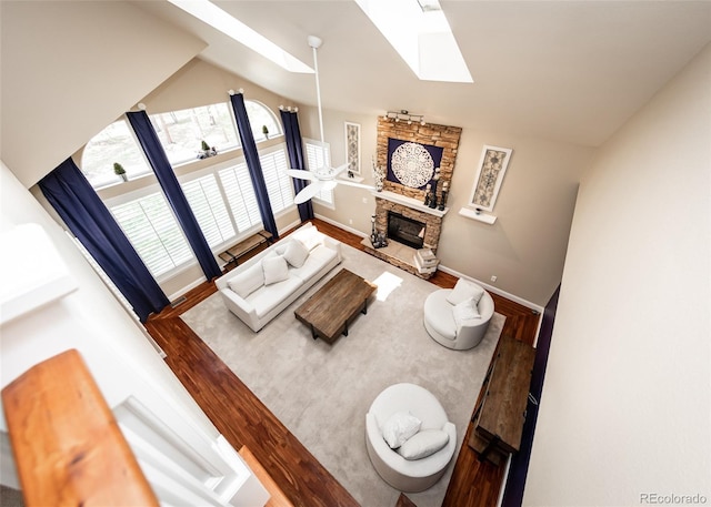 1530 Woodrose Ct, Colorado Springs, CO 80921 - living area with a skylight, wood finished floors, a fireplace, baseboards, and vaulted ceiling