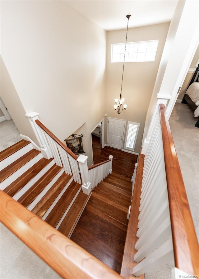 1530 Woodrose Ct, Colorado Springs, CO 80921 - stairway featuring a chandelier, a high ceiling, and wood finished floors
