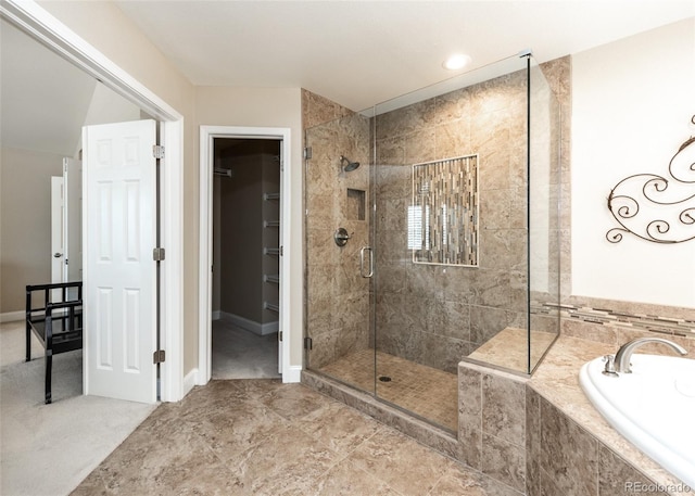 1530 Woodrose Ct, Colorado Springs, CO 80921 - bathroom with a bath, a shower stall, a spacious closet, and baseboards