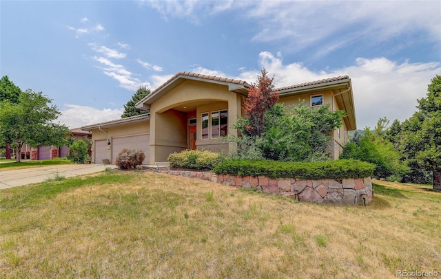 view of front facade with a garage, driveway, a front lawn, and stucco siding