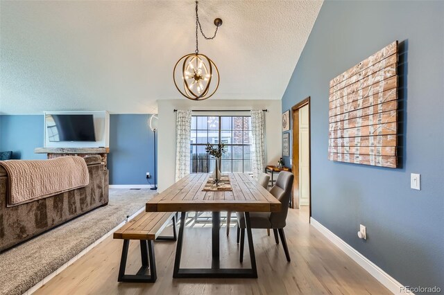 8820 W 80th Dr, Arvada, CO 80005 - dining area featuring a textured ceiling, a chandelier, baseboards, wood finished floors, and vaulted ceiling