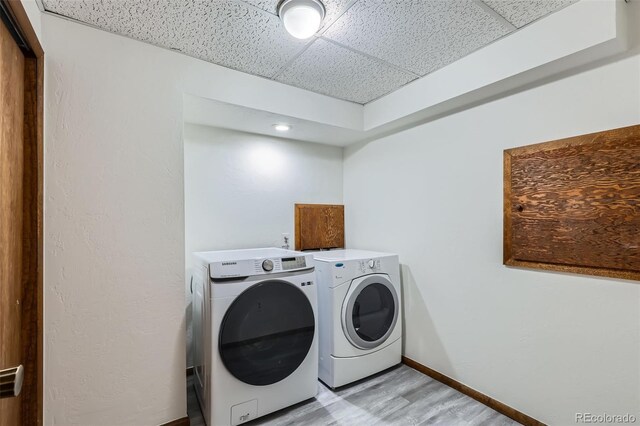 8820 W 80th Dr, Arvada, CO 80005 - laundry area with washing machine and dryer, baseboards, and light wood-type flooring