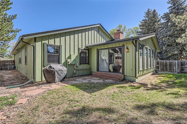 8820 W 80th Dr, Arvada, CO 80005 - rear view of house featuring a chimney, board and batten siding, and central AC