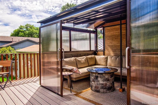 deck featuring an outdoor living space with a fire pit