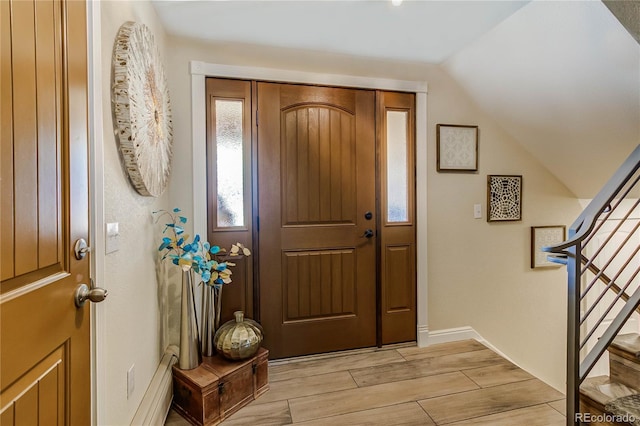 entrance foyer with lofted ceiling and light hardwood / wood-style floors