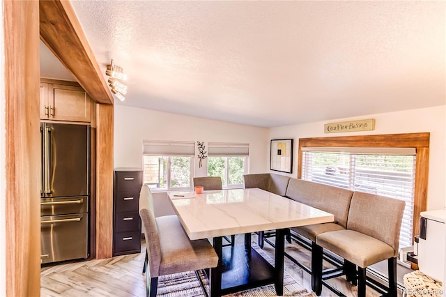 dining room with a textured ceiling and light hardwood / wood-style floors