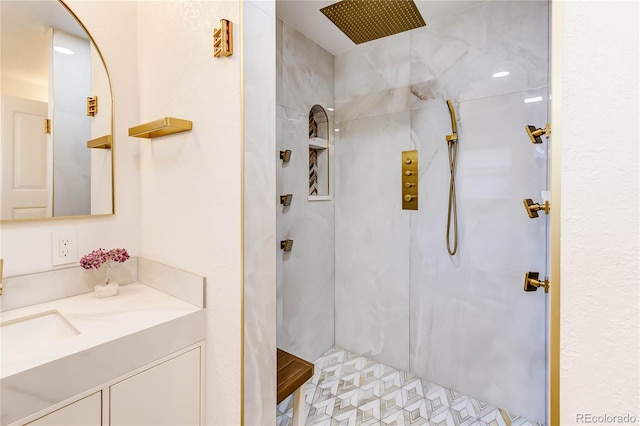 bathroom featuring tiled shower and vanity