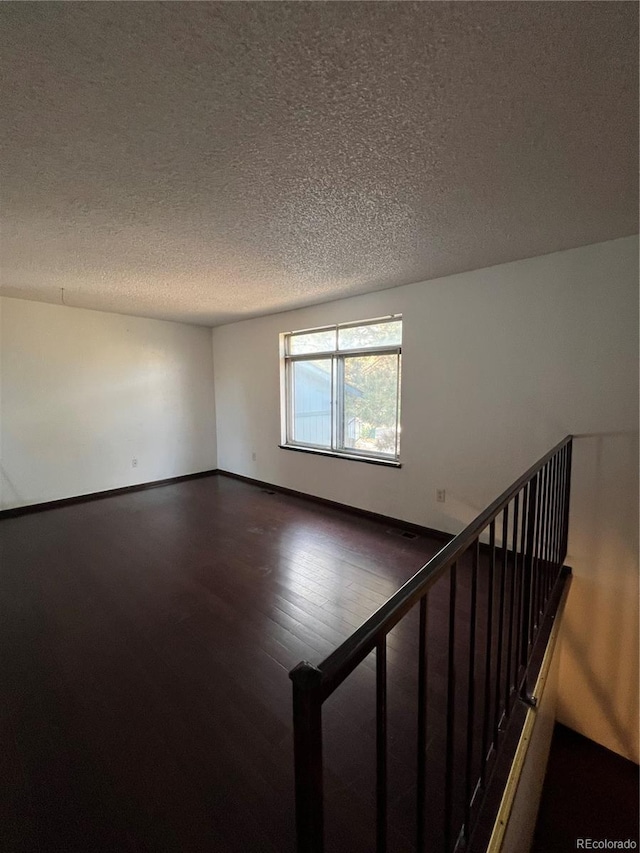 16032 E Floyd Ave, Aurora, CO 80013 - spare room with dark wood-type flooring and a textured ceiling