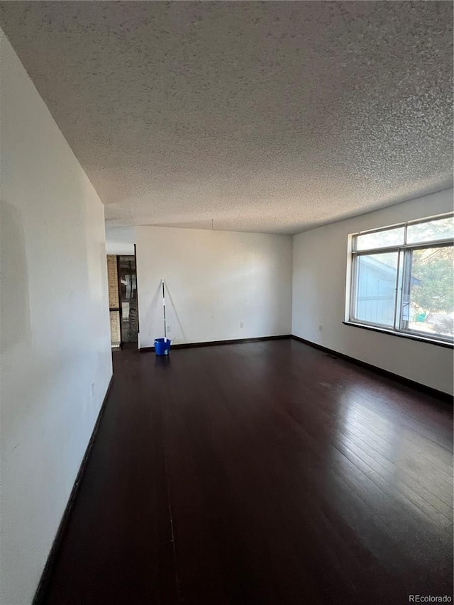 16032 E Floyd Ave, Aurora, CO 80013 - unfurnished room with a textured ceiling and dark wood finished floors