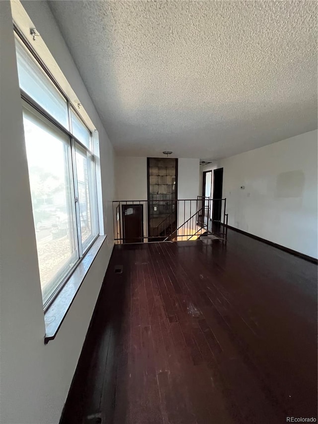 16032 E Floyd Ave, Aurora, CO 80013 - unfurnished living room with a textured ceiling and hardwood / wood-style flooring