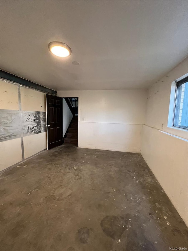 16032 E Floyd Ave, Aurora, CO 80013 - empty room with unfinished concrete floors and stairway