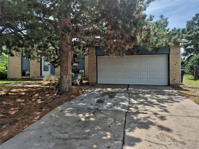 16032 E Floyd Ave, Aurora, CO 80013 - view of property hidden behind natural elements featuring brick siding and driveway