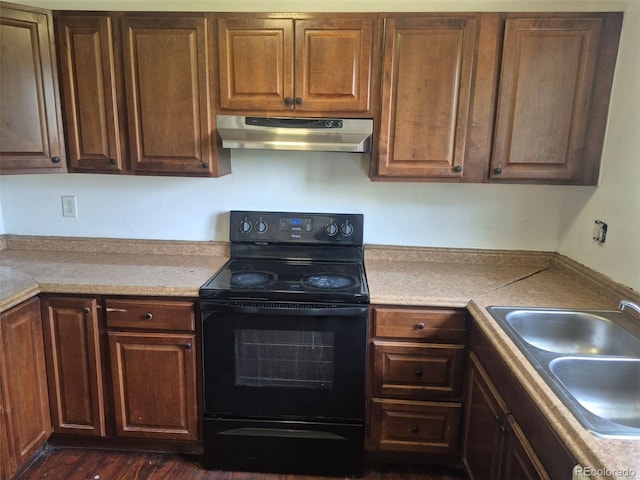 16032 E Floyd Ave, Aurora, CO 80013 - kitchen with black / electric stove, under cabinet range hood, a sink, light countertops, and dark wood-type flooring