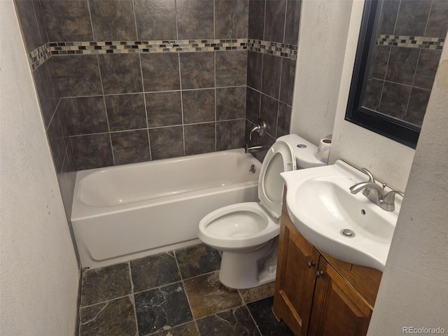 16032 E Floyd Ave, Aurora, CO 80013 - full bath with a textured wall, stone tile flooring, vanity, toilet, and bathing tub / shower combination