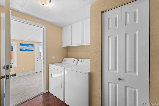 washroom with light hardwood / wood-style floors, cabinets, and washer and dryer