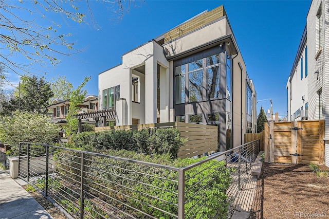 427 Milwaukee St, Denver, CO 80206 - view of side of property with fence, a gate, and stucco siding