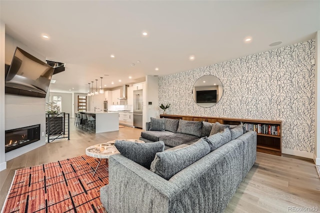 427 Milwaukee St, Denver, CO 80206 - living room featuring recessed lighting, an accent wall, wallpapered walls, and light wood-style flooring