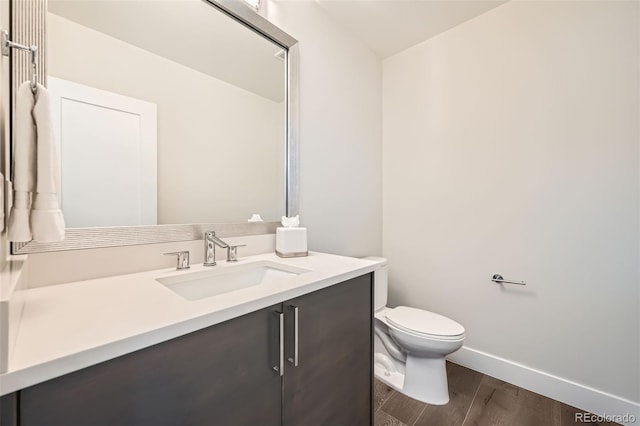 427 Milwaukee St, Denver, CO 80206 - bathroom with vanity, baseboards, toilet, and wood finished floors