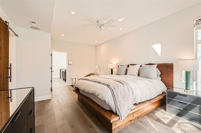 427 Milwaukee St, Denver, CO 80206 - bedroom featuring ceiling fan, a barn door, recessed lighting, wood finished floors, and visible vents