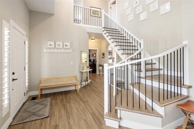 13777 W Amherst Way, Lakewood, CO 80228 - entryway featuring wood finished floors, stairway, baseboards, and a high ceiling