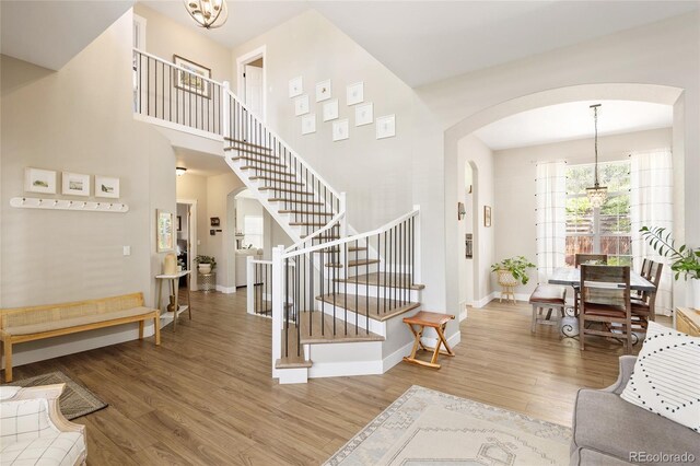 13777 W Amherst Way, Lakewood, CO 80228 - foyer entrance featuring arched walkways, stairs, wood finished floors, baseboards, and a chandelier