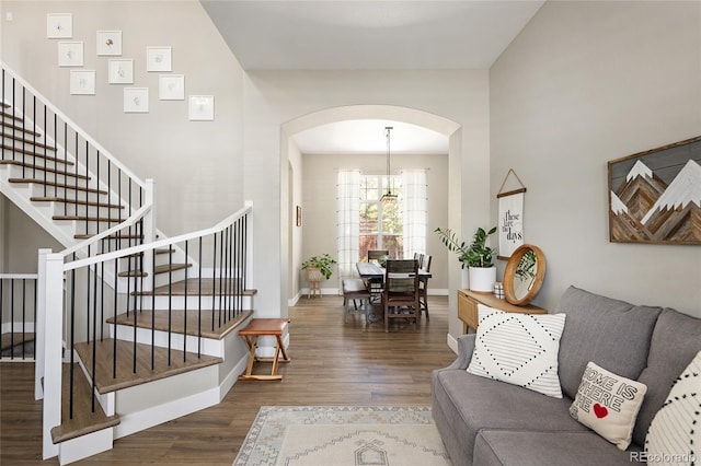 13777 W Amherst Way, Lakewood, CO 80228 - living area featuring arched walkways, wood finished floors, stairs, a chandelier, and baseboards