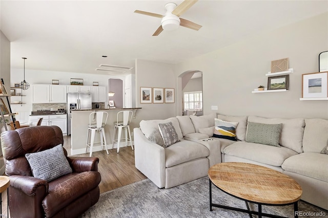 13777 W Amherst Way, Lakewood, CO 80228 - living room featuring arched walkways, a ceiling fan, and wood finished floors