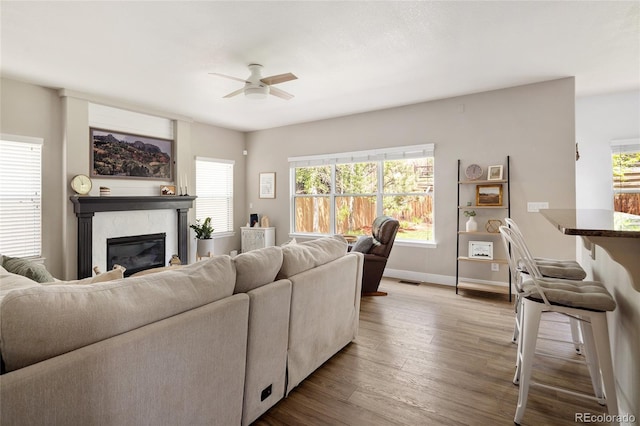13777 W Amherst Way, Lakewood, CO 80228 - living area featuring ceiling fan, wood finished floors, a premium fireplace, and baseboards
