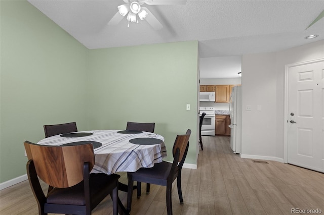 dining room featuring baseboards, light wood finished floors, a ceiling fan, and recessed lighting