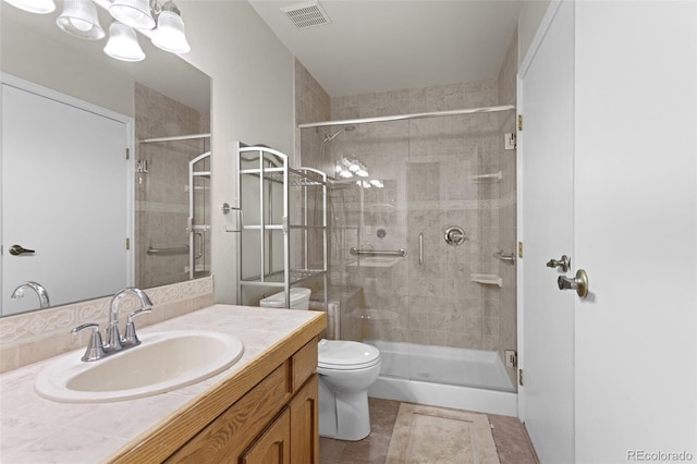 bathroom featuring a stall shower, toilet, vanity, and tile patterned floors